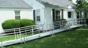 Aluminum ramp next to a white, panel house