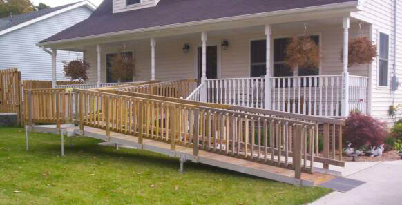 Aluminum ramp next to a white, panel house